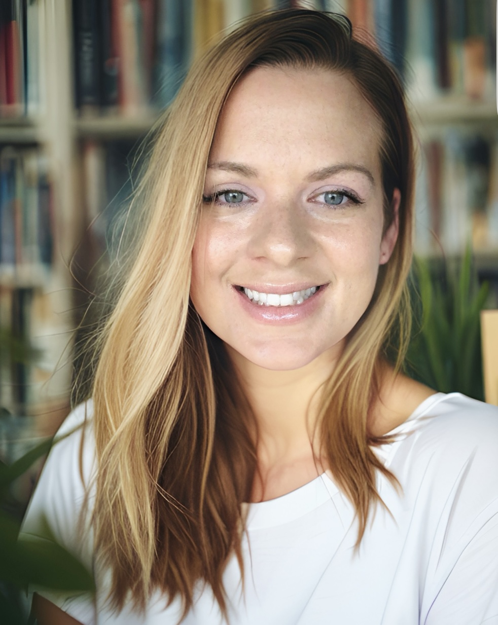 Lisa D’Anna smiling in front of her bookshelves
